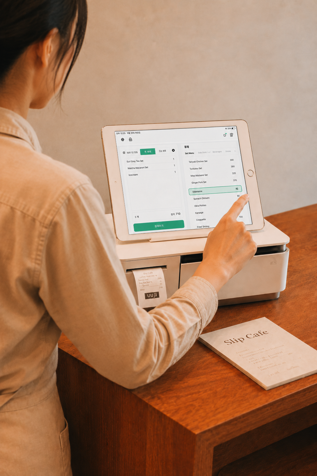 A shop owner using Slip POS on an iPad at the counter